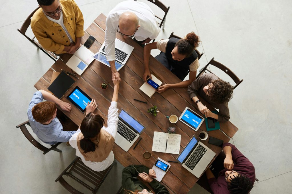 TimeBinder's blockchain partnership program represented as people shaking hands, aerial view.