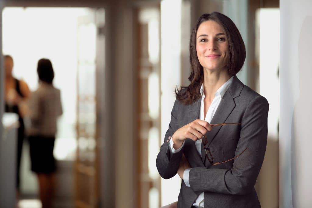 Professional woman in business attire thinking about real world blockchain timestamping.