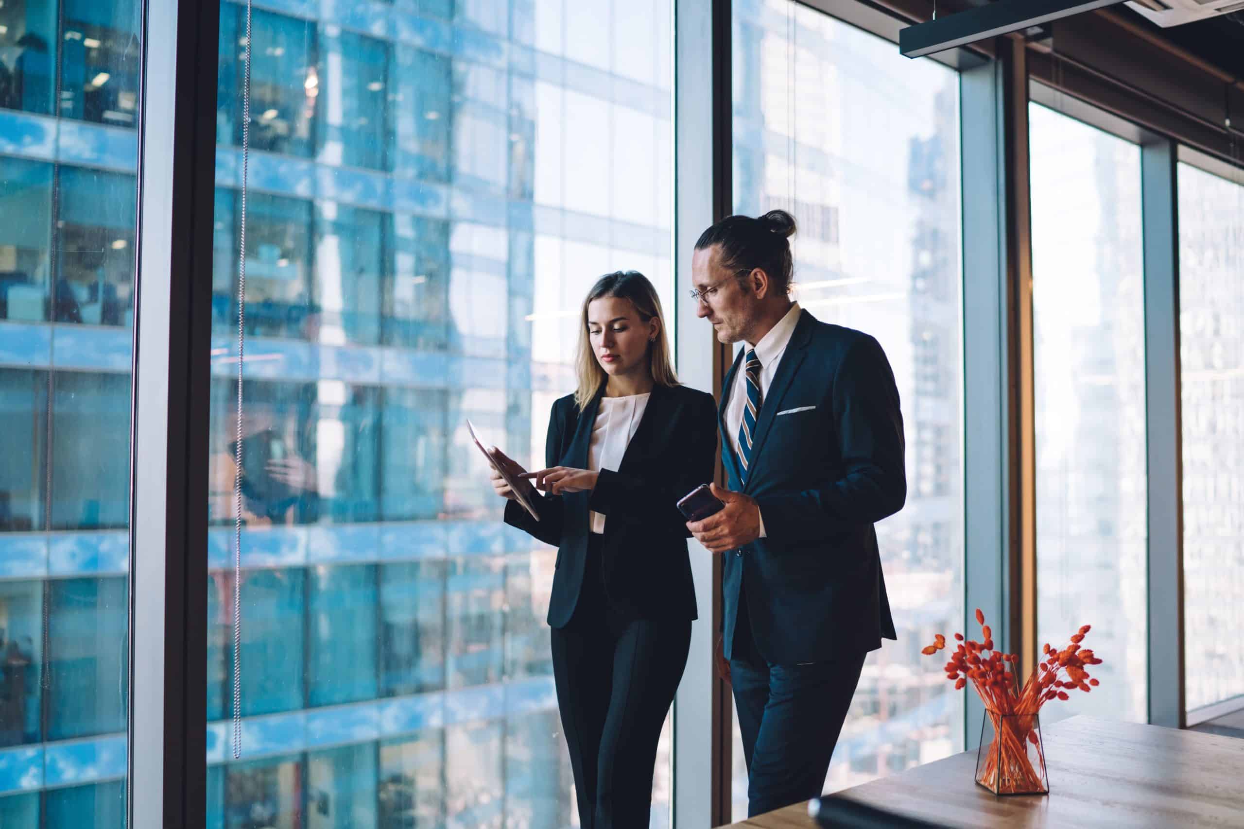 Business professionals discussing by window. TimeBinder Pricing for Immutable Proof.