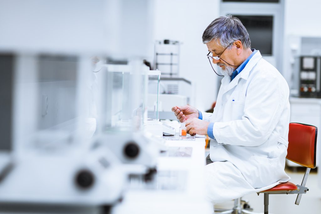 Researcher analysing lab data with blockchain timestamping technology for data integrity.