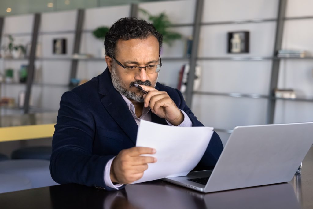 Lawyer reviewing documents at desk. Blockchain Verification for Law Firms.