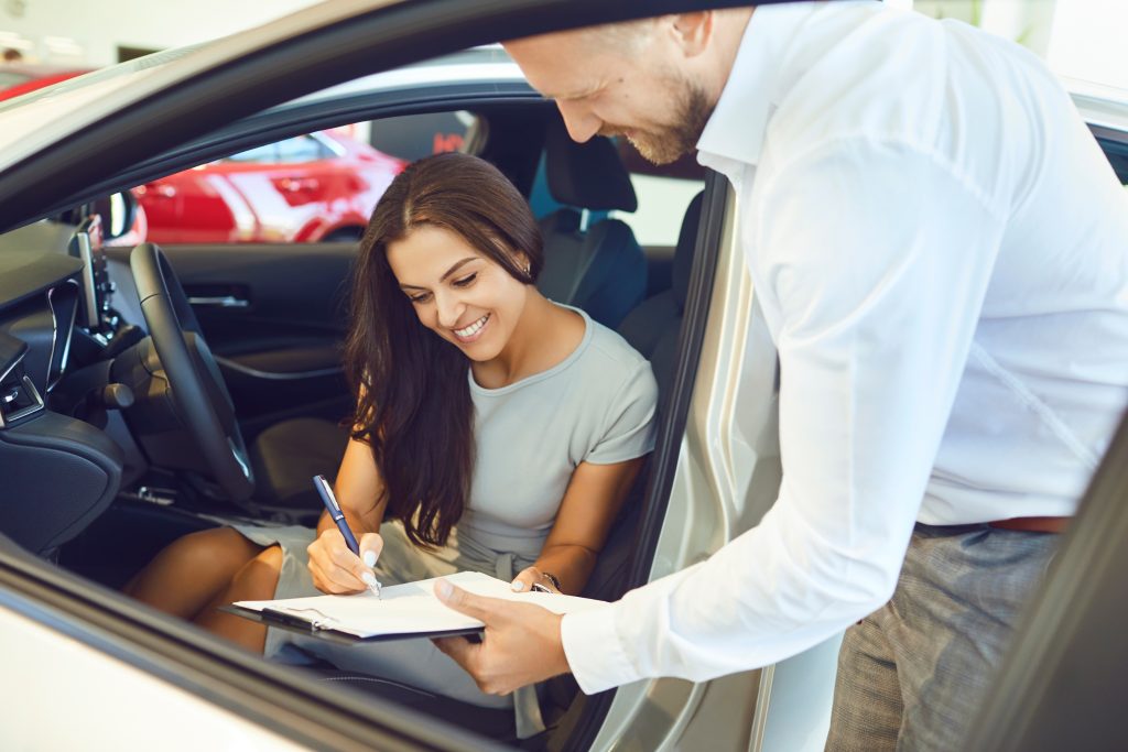 Woman signing documents in car. Rental Document Verification with TimeBinder.