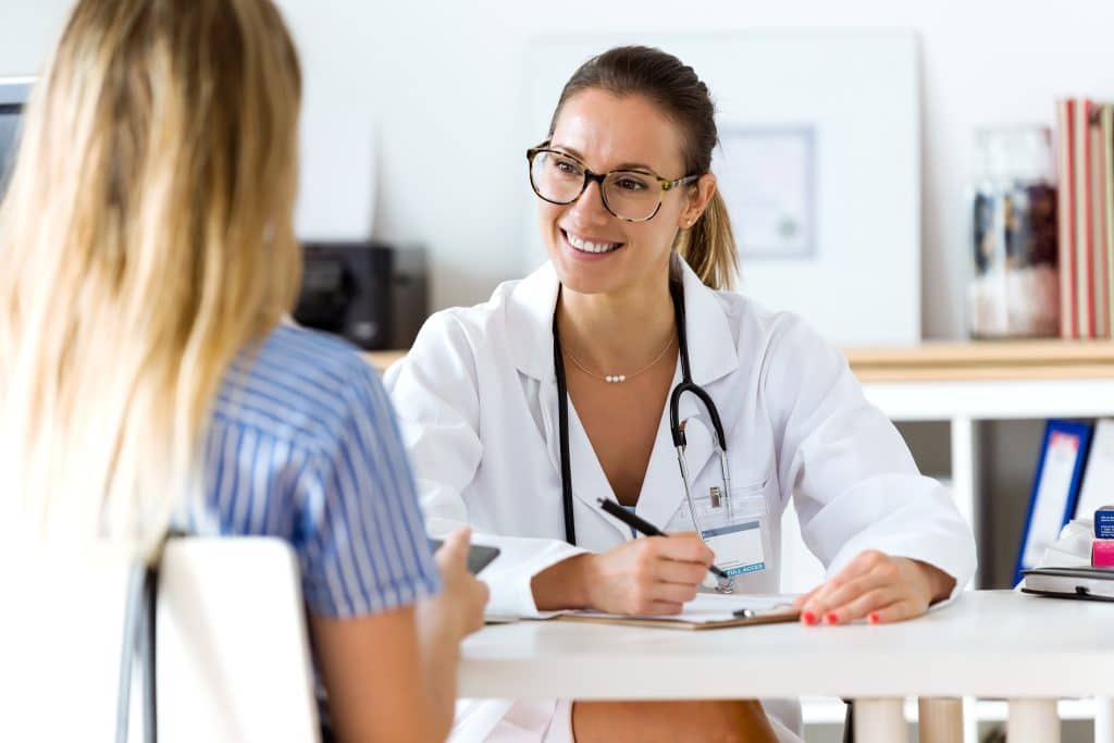 Doctor smiling: blockchain medical record timestamping for hospital data integrity.