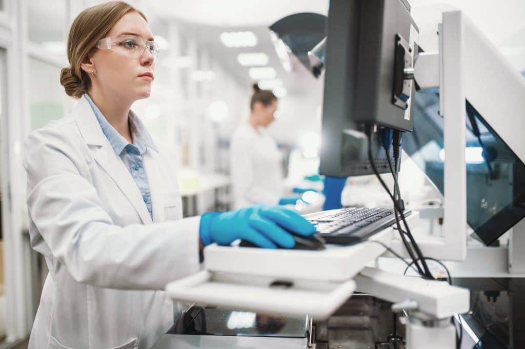 Researcher analysing lab data with blockchain research timestamping technology for data integrity.